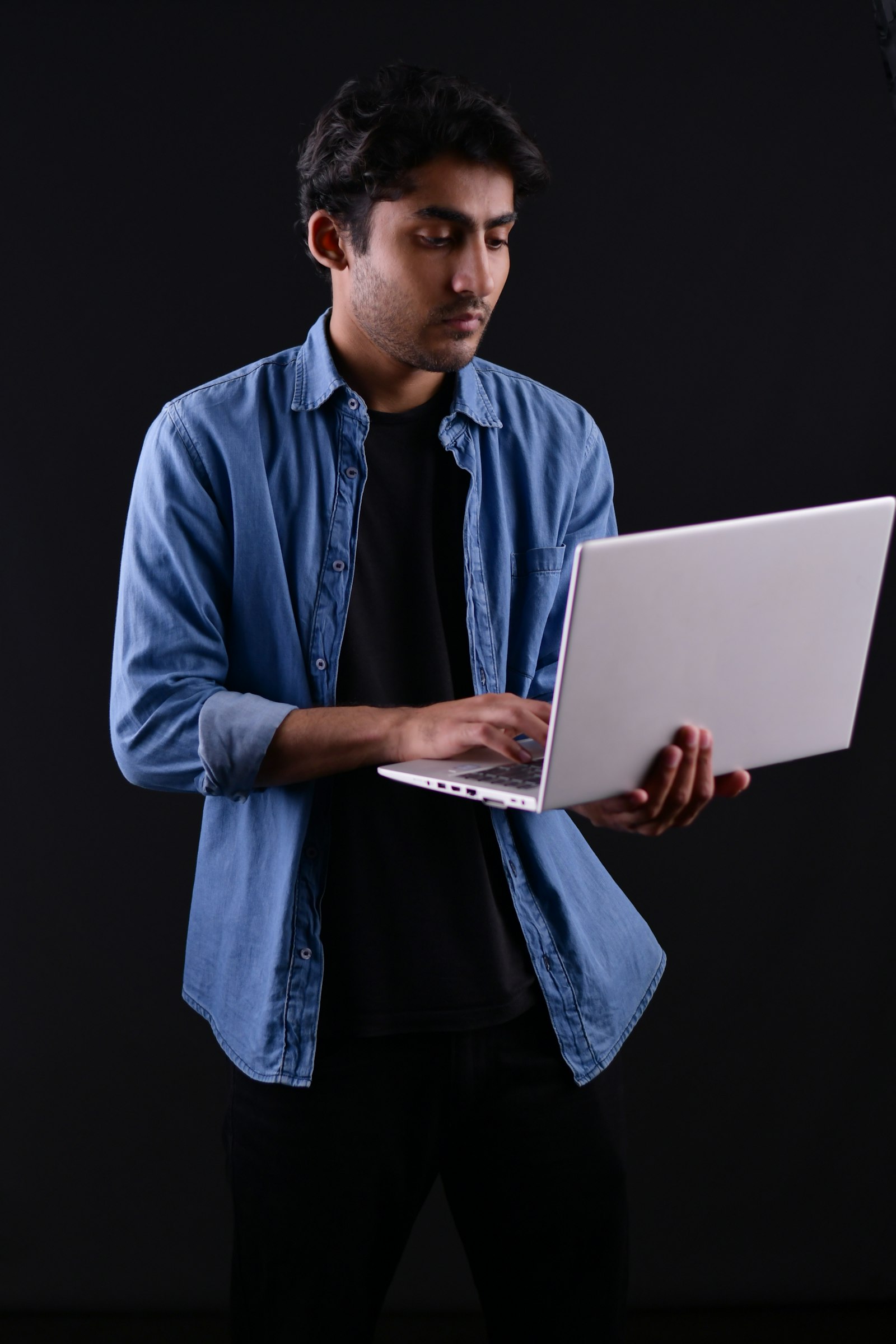 A young man using a laptop at home.