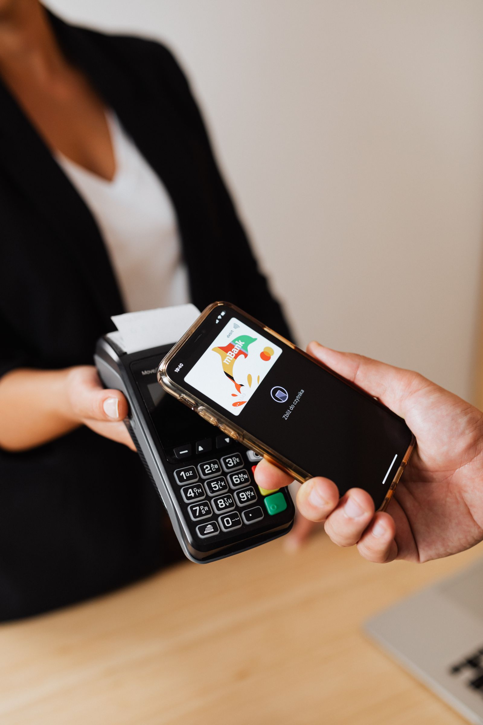 Person paying contactlessly with a smartphone at a payment terminal
