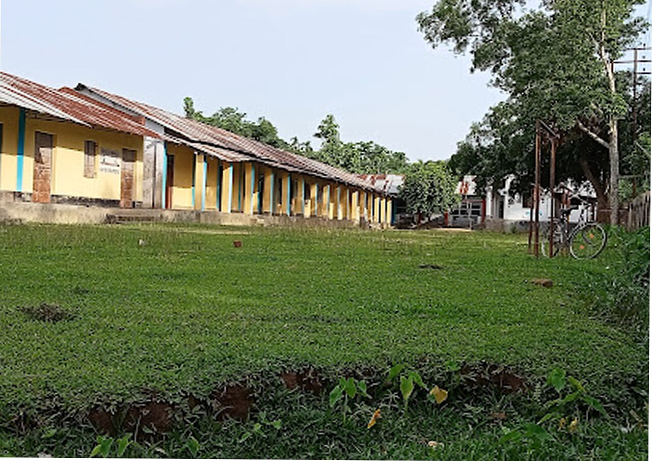 Long single-storey school buildings around a green lawn