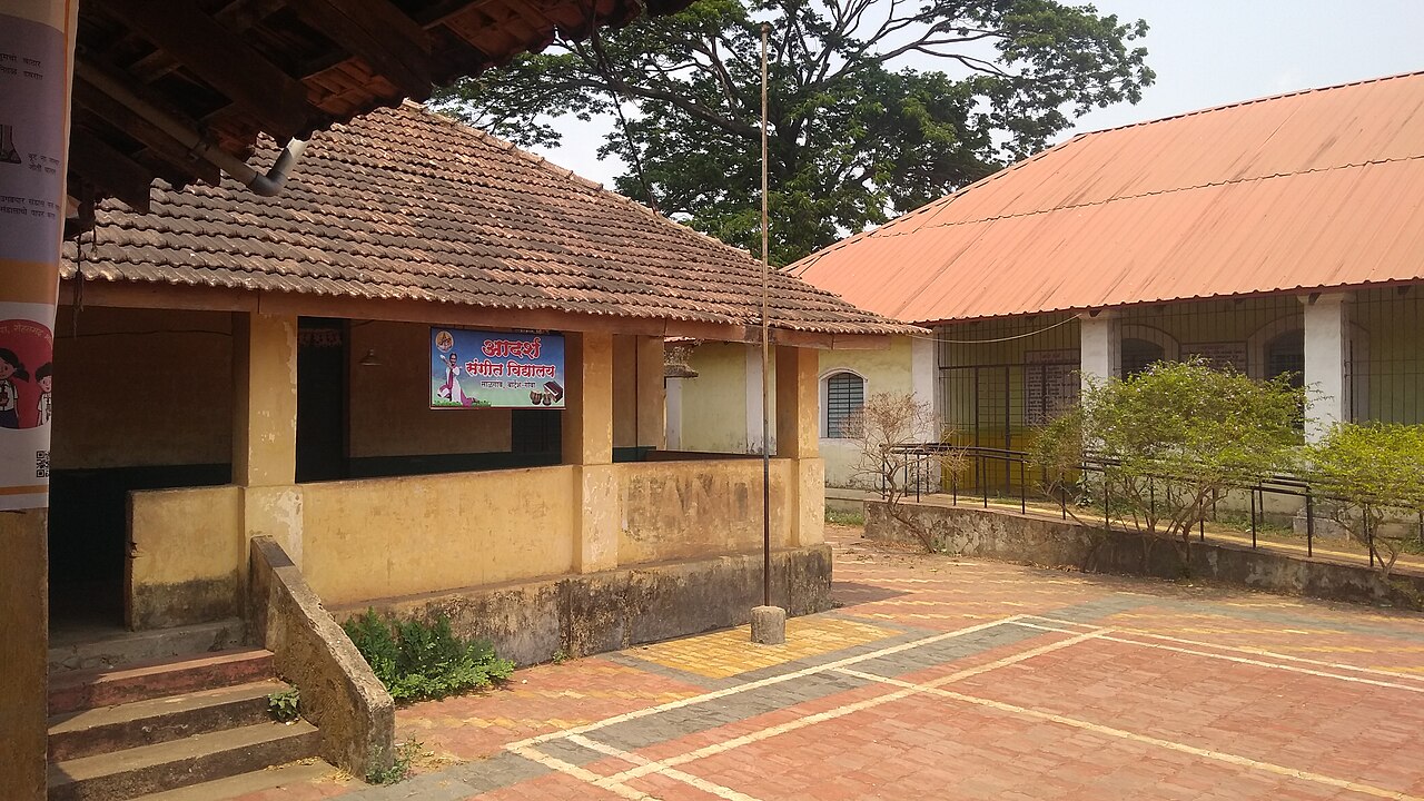A school building with a tiled roof and an open courtyard in Saligao, Goa