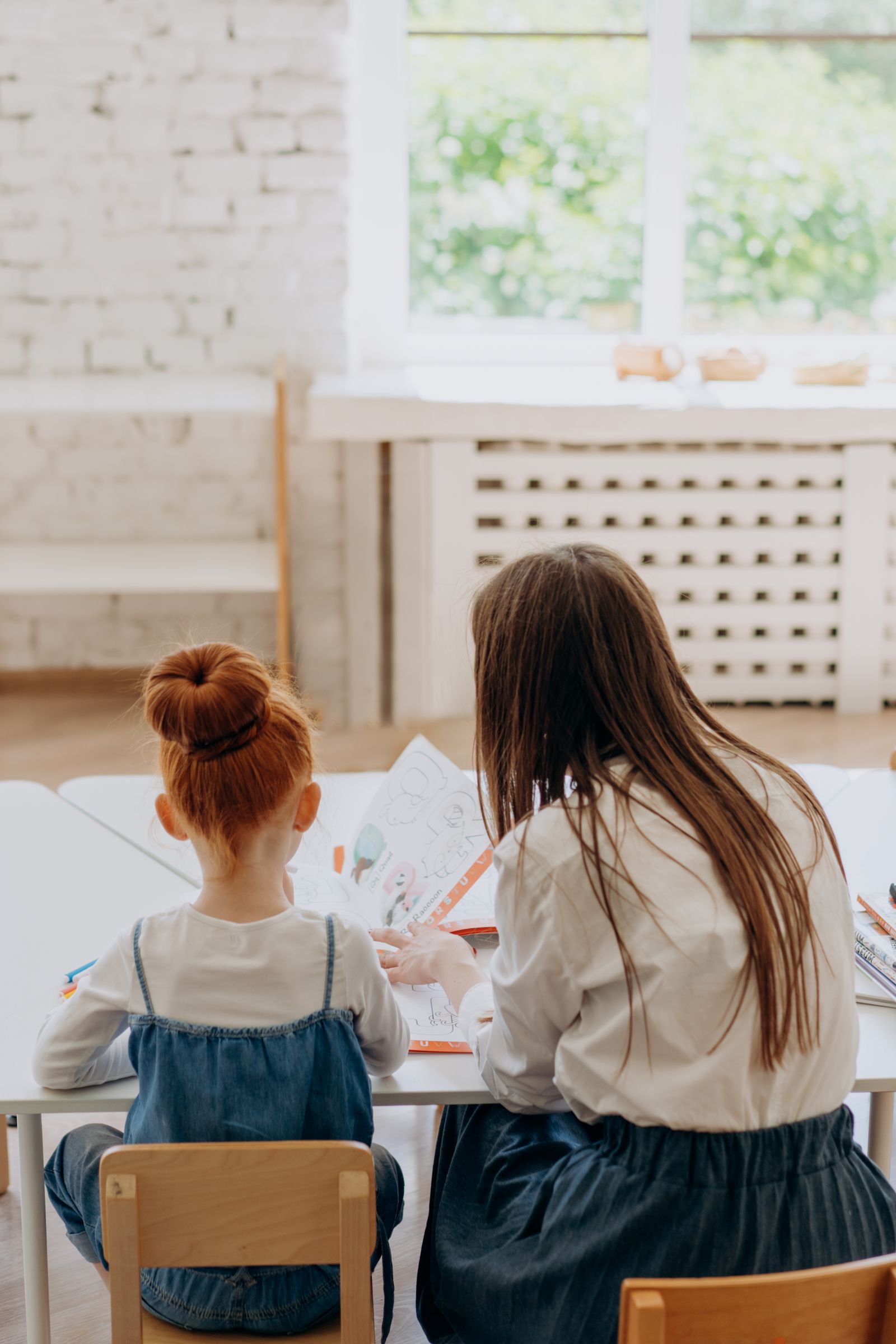 Mother and daughter working through a study task at a table.